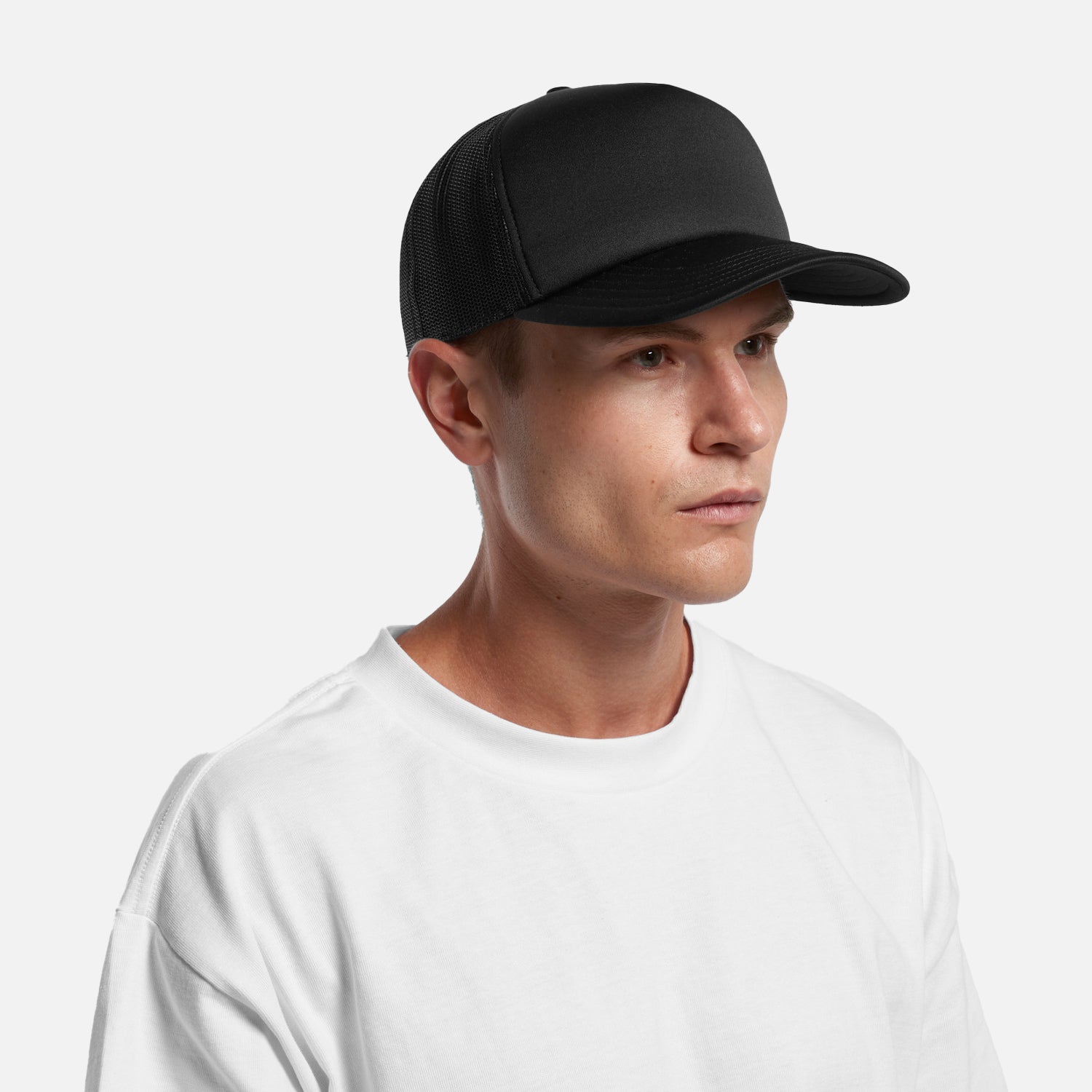 Male model wearing Look Design custom branded trucker cap in black