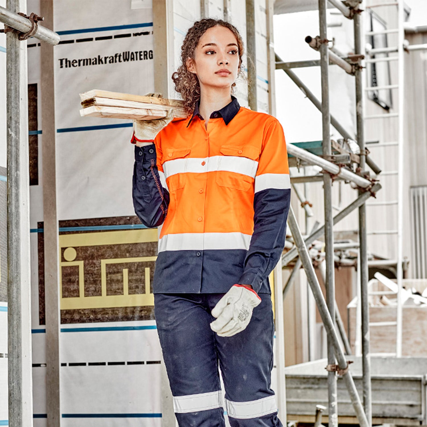 Female worker wearing Look Design custom branded collared Hi Vis in bright orange and navy with reflective silver stripes