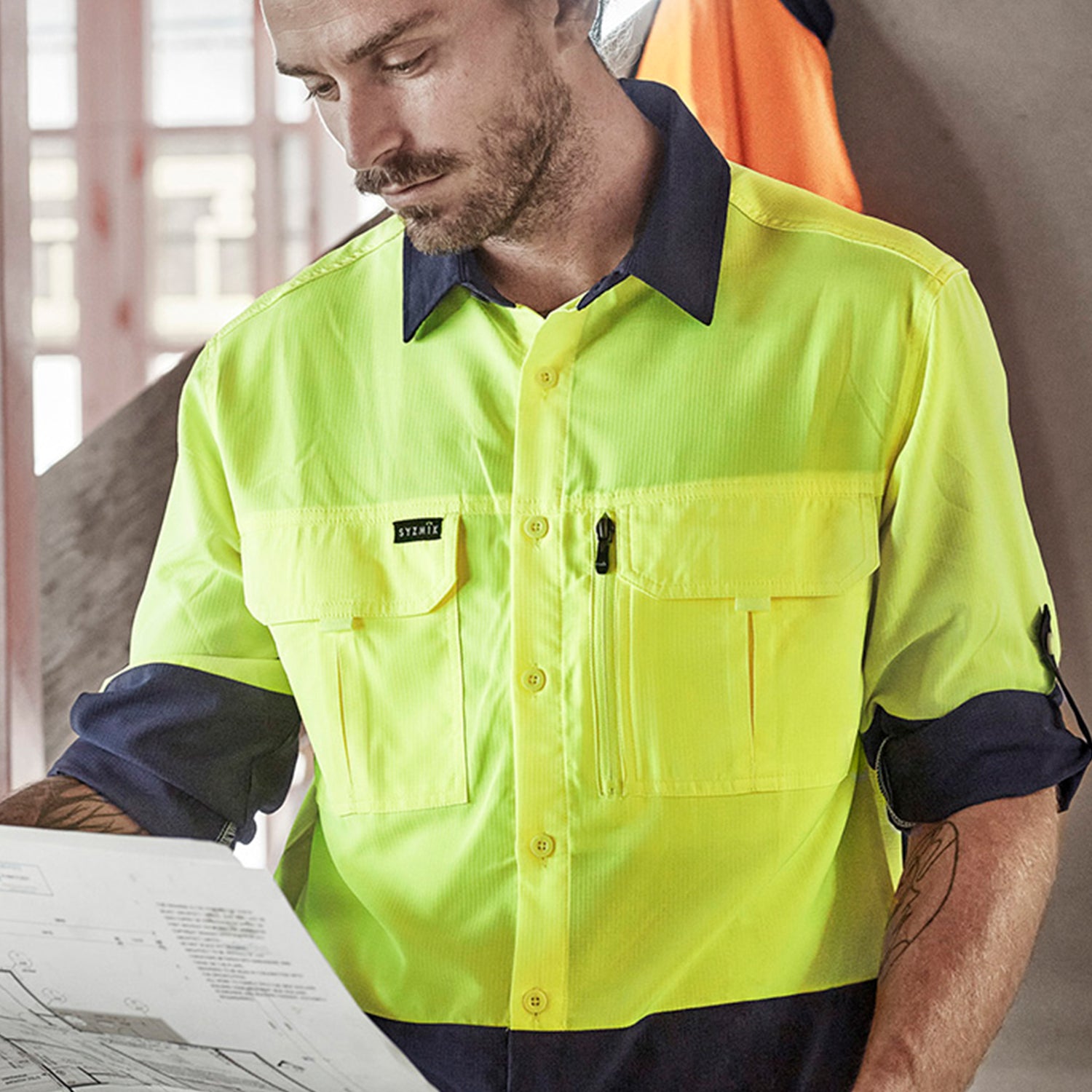Male worker wearing Look Design custom branded collared Hi Vis in bright yellow and navy