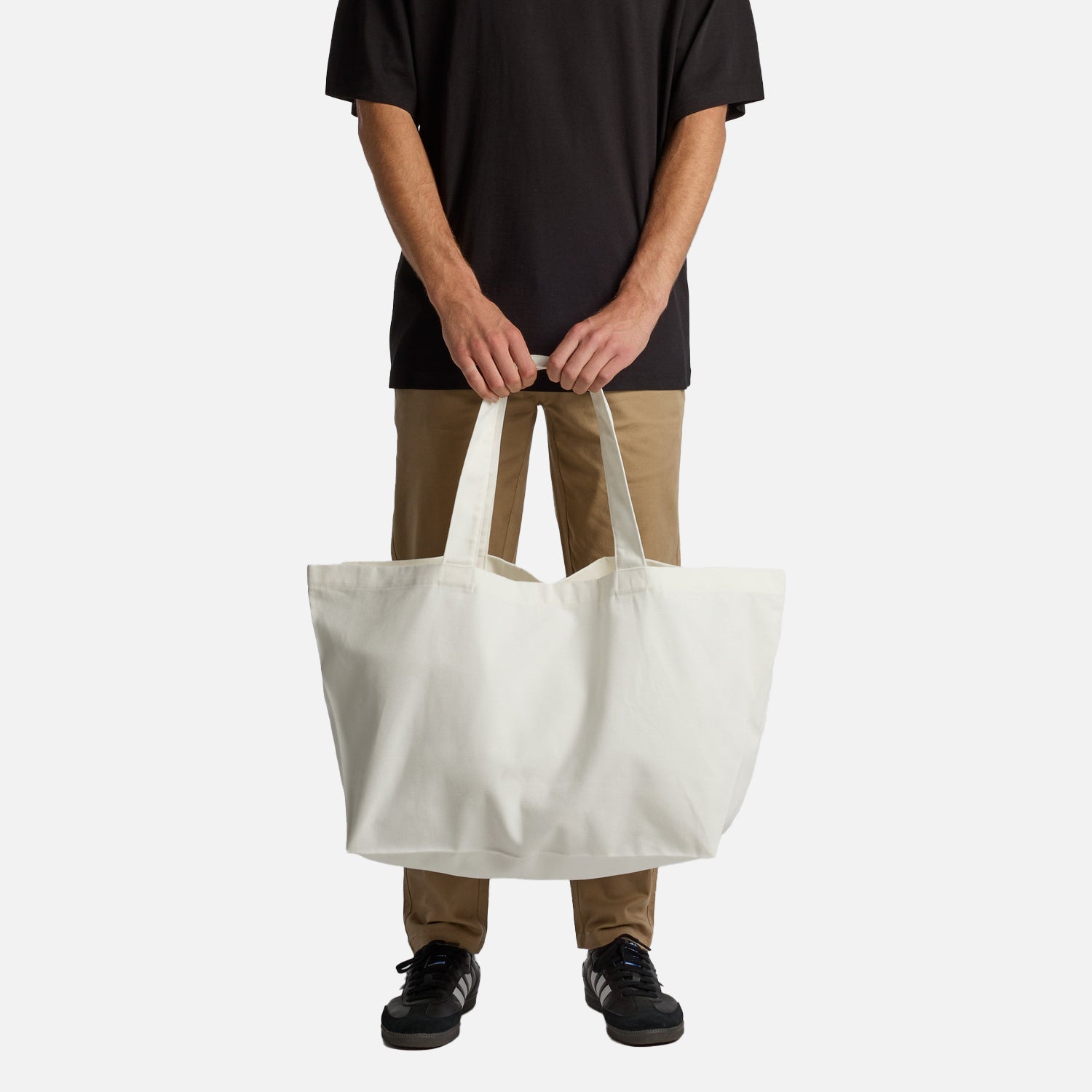 Male model holding Look Design custom branded shoulder tote bag in white