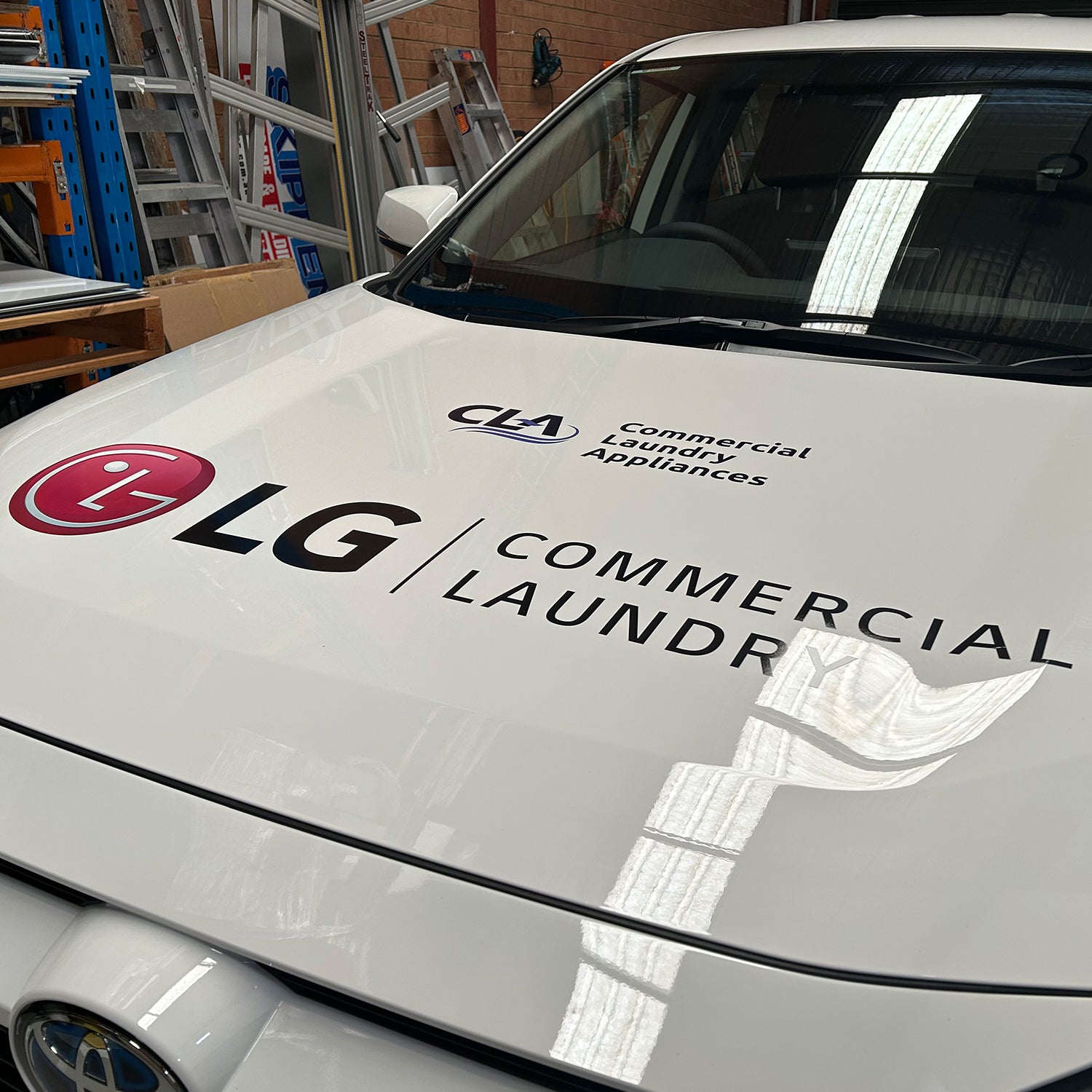 Look Design custom branded vehicle signage on the hood of a white vehicle